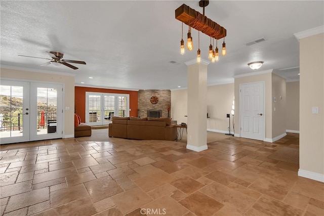 unfurnished living room with ornamental molding, french doors, baseboards, and stone tile floors