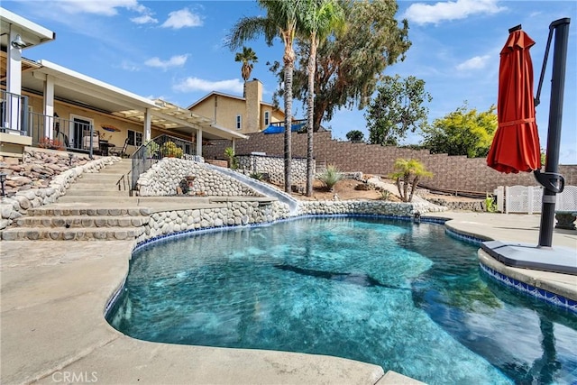 view of pool featuring a fenced in pool, a patio, stairway, a water slide, and a fenced backyard