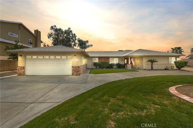 view of front of home with an attached garage, brick siding, concrete driveway, and a front yard