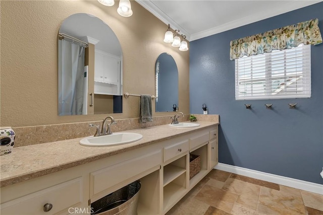 full bath featuring crown molding, a sink, baseboards, and double vanity