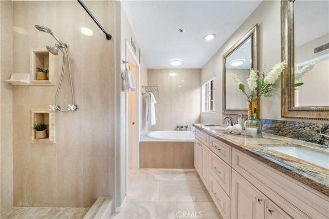 full bath with a tile shower, double vanity, a sink, and a bath