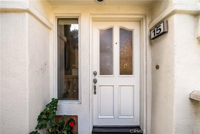 property entrance featuring stucco siding