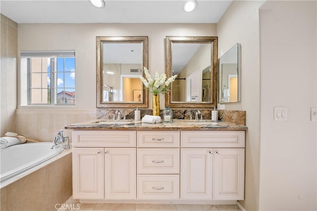 full bath featuring a garden tub, a sink, visible vents, and double vanity