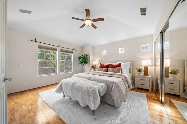 bedroom featuring light wood-type flooring, ceiling fan, and visible vents