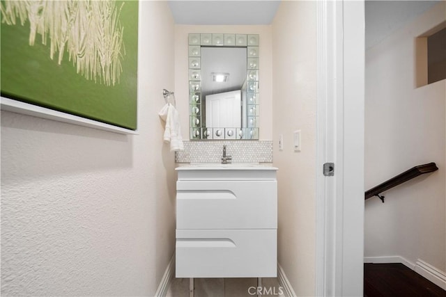 bathroom featuring backsplash, vanity, and baseboards