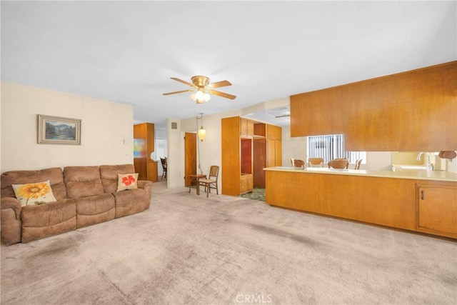 living area with a ceiling fan and light carpet