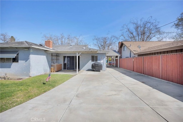 exterior space featuring a front lawn, a chimney, fence, and stucco siding