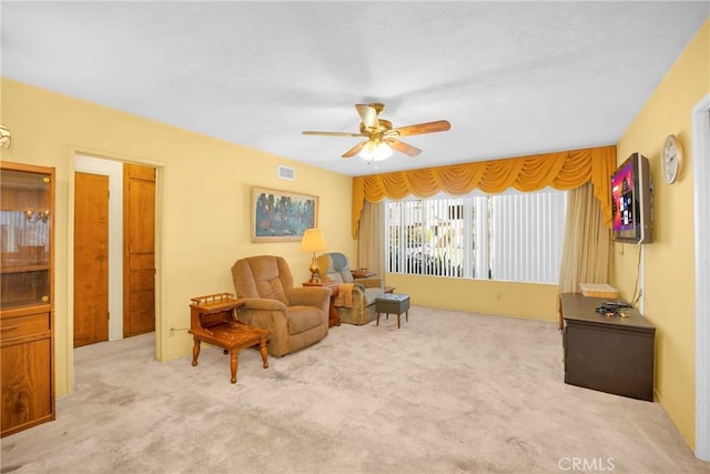 sitting room featuring visible vents, ceiling fan, and carpet flooring