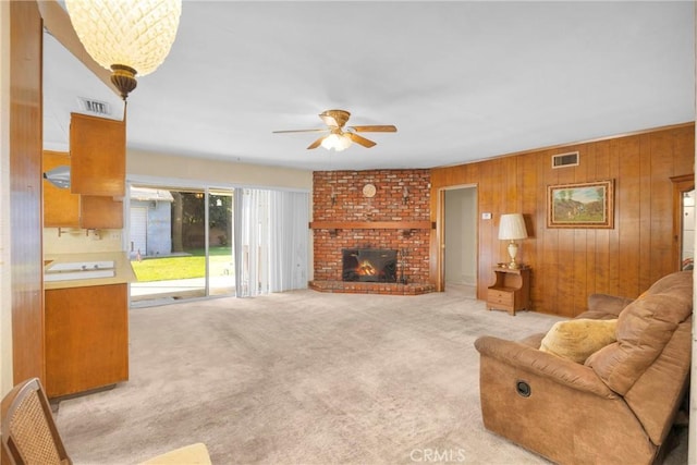 living room featuring light carpet, a fireplace, and visible vents