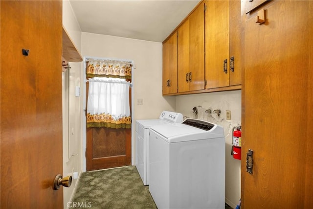 clothes washing area featuring carpet, washing machine and clothes dryer, and cabinet space