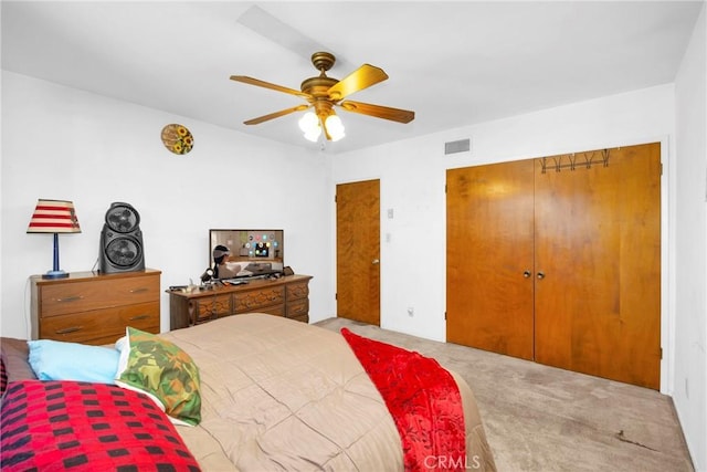 carpeted bedroom with a ceiling fan, a closet, and visible vents