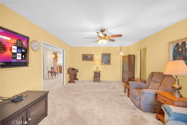 living area with ceiling fan and light colored carpet