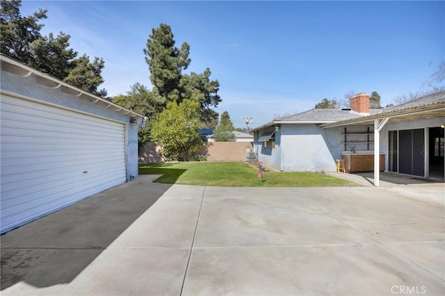 exterior space featuring a garage, a patio area, fence, and concrete driveway