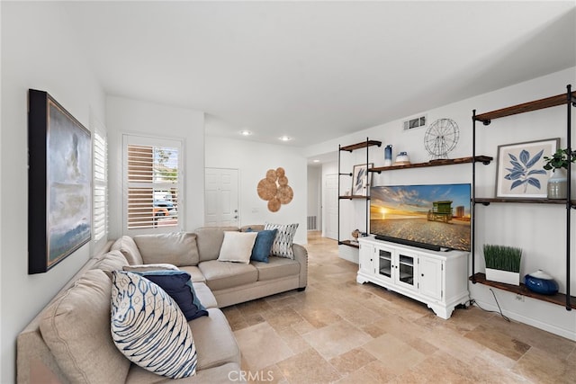 living room featuring baseboards, visible vents, stone finish floor, and recessed lighting