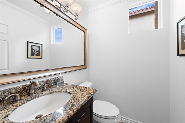 half bath featuring crown molding, vanity, and toilet
