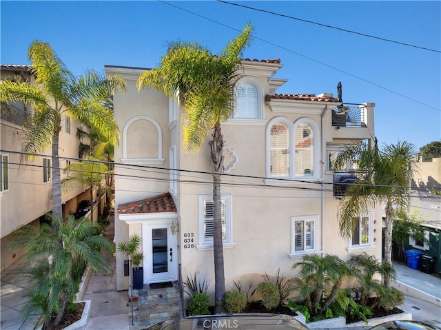 mediterranean / spanish-style home with a tile roof and stucco siding