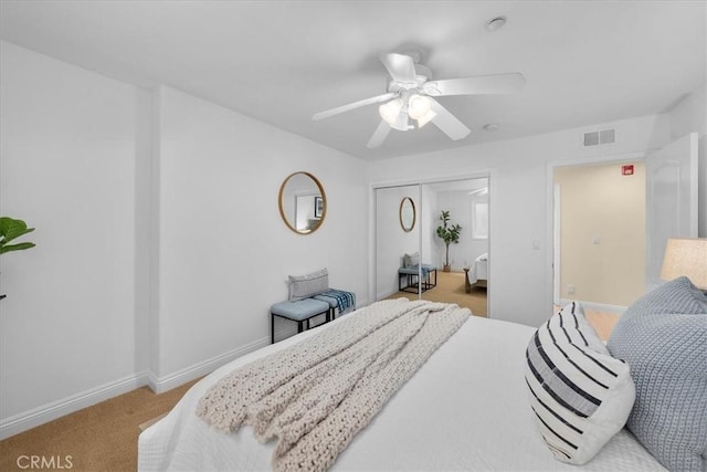 carpeted bedroom with baseboards, visible vents, a closet, and ceiling fan