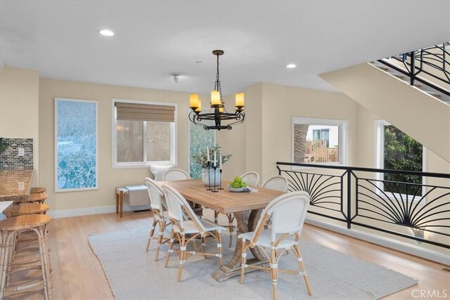 dining space featuring a notable chandelier, wood finished floors, recessed lighting, and baseboards