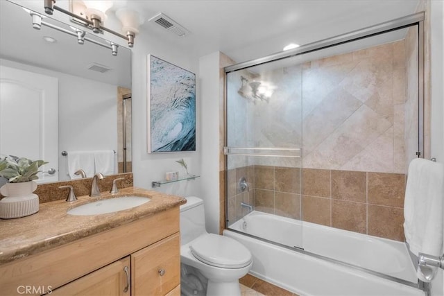 bathroom with visible vents, shower / bath combination with glass door, vanity, and toilet