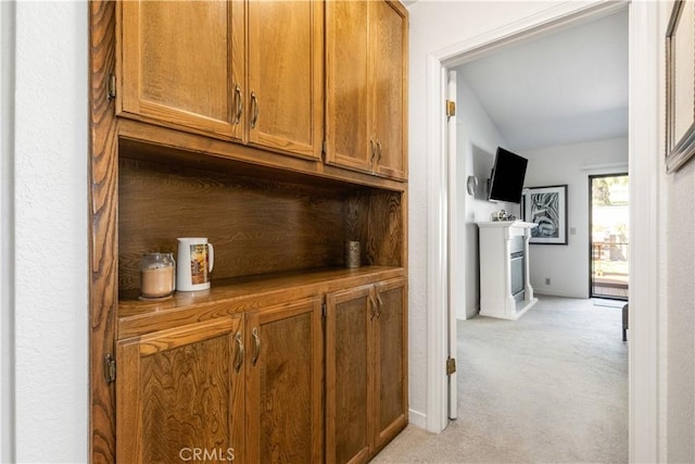 hall featuring light carpet and baseboards