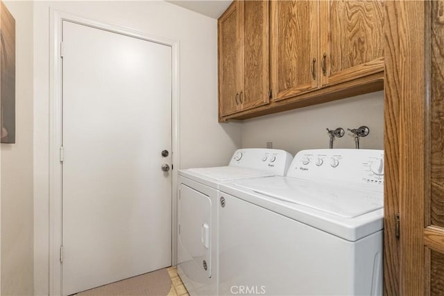 clothes washing area with cabinet space and separate washer and dryer