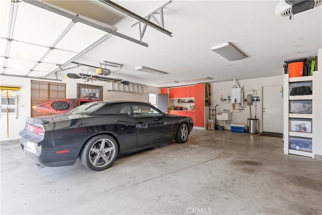 garage with a garage door opener, water heater, and a sink