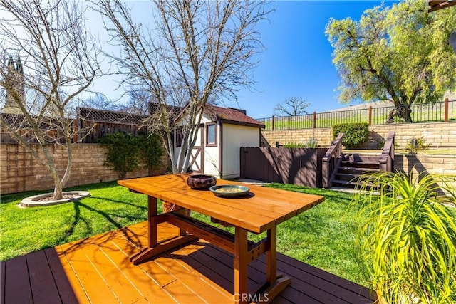 wooden deck featuring a shed, a lawn, an outdoor structure, and a fenced backyard