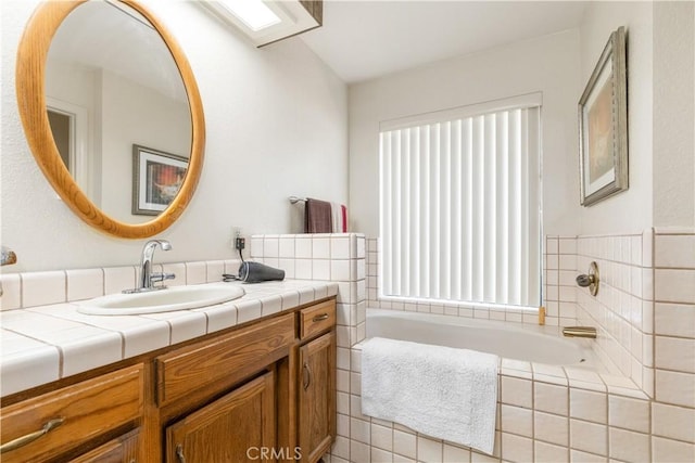 bathroom featuring a garden tub and vanity