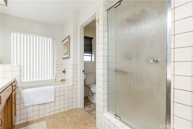 full bathroom featuring toilet, vanity, a bath, tile patterned floors, and a stall shower