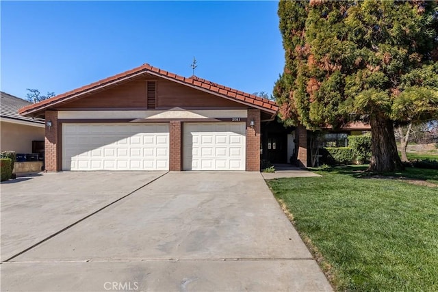 view of front of house with a garage, driveway, a front lawn, and brick siding