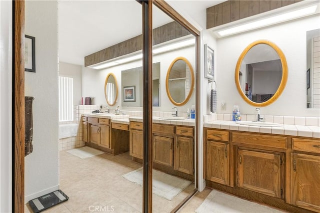 full bathroom with a garden tub, two vanities, and a sink