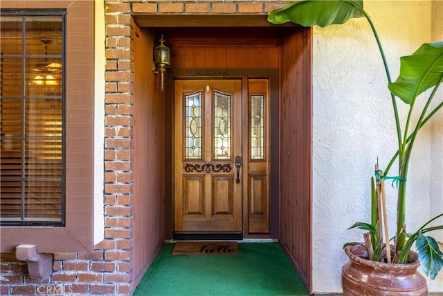 entrance to property with brick siding and stucco siding