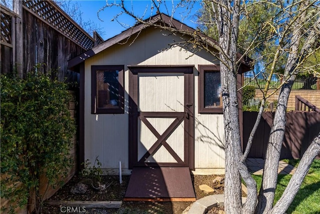 view of shed featuring fence