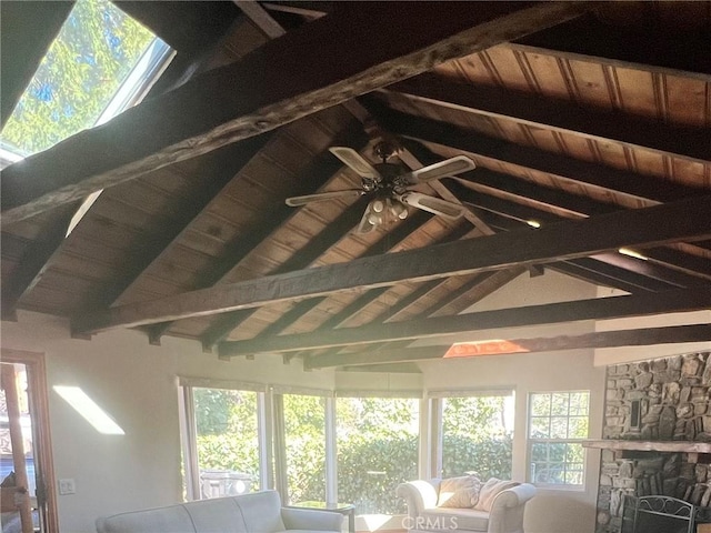 unfurnished sunroom featuring a healthy amount of sunlight, wood ceiling, and a stone fireplace