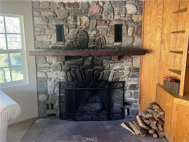 details with baseboards and a stone fireplace