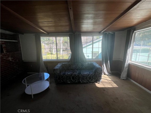 interior space with carpet, wood ceiling, and beam ceiling