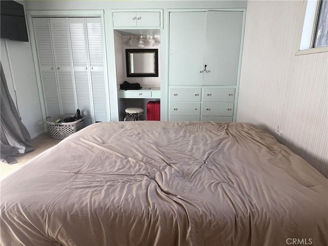 bedroom with carpet and two closets