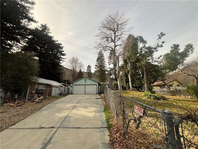 view of front facade featuring a garage, fence, and an outdoor structure