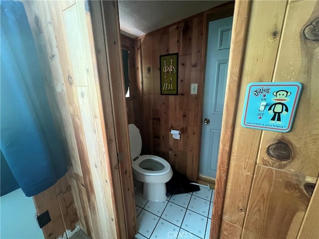 bathroom with toilet and wooden walls