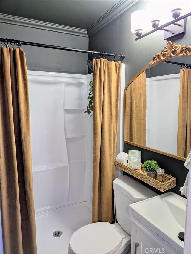 bathroom featuring a shower with shower curtain, vanity, toilet, and crown molding