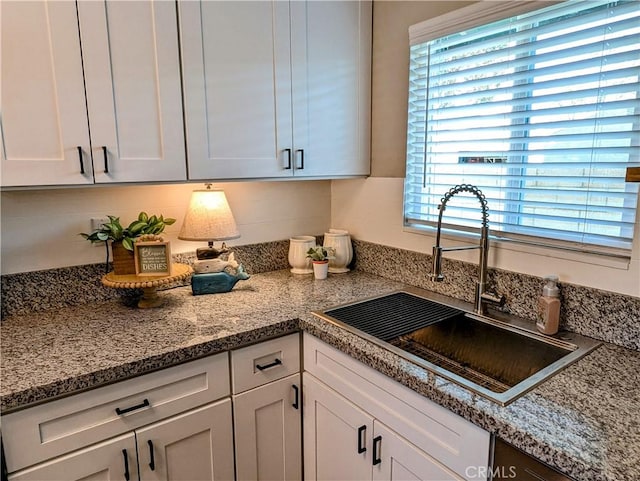 kitchen featuring a sink and white cabinets