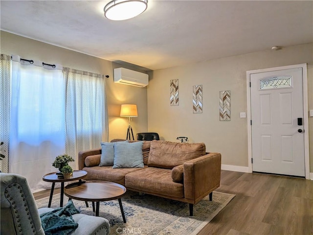 living area featuring wood finished floors, baseboards, and a wall mounted AC