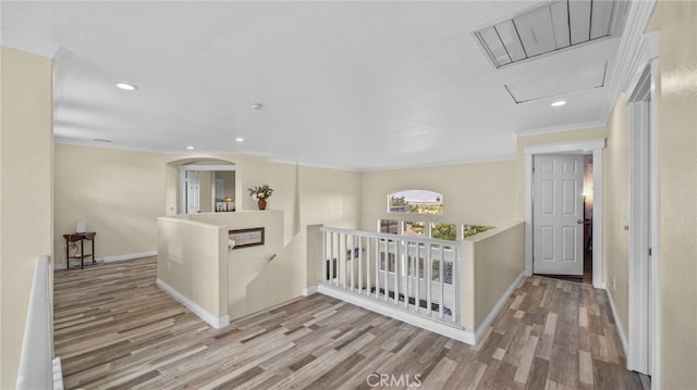 corridor featuring crown molding, visible vents, wood finished floors, and an upstairs landing