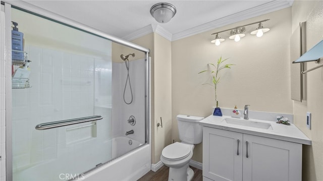 bathroom with bath / shower combo with glass door, toilet, ornamental molding, vanity, and baseboards