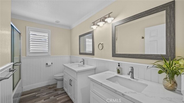 bathroom featuring two vanities, wainscoting, and a sink