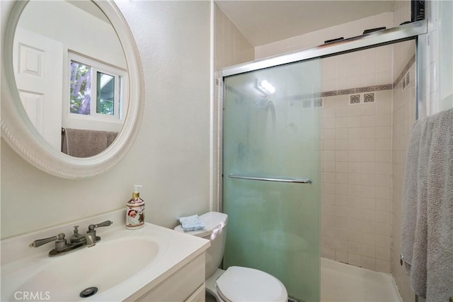 bathroom featuring a stall shower, vanity, and toilet