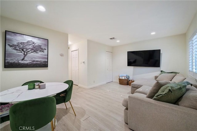 living area with light wood-style floors, baseboards, visible vents, and recessed lighting