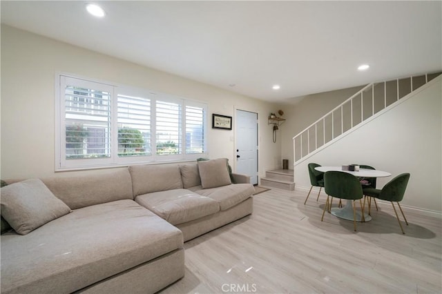 living area featuring recessed lighting, baseboards, stairway, and light wood finished floors