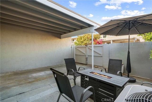 view of patio / terrace with a fire pit, a gate, and fence