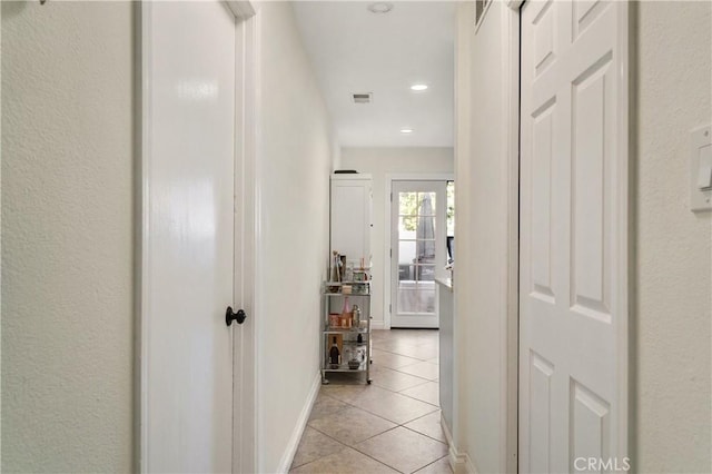 hall with light tile patterned floors, baseboards, visible vents, and recessed lighting